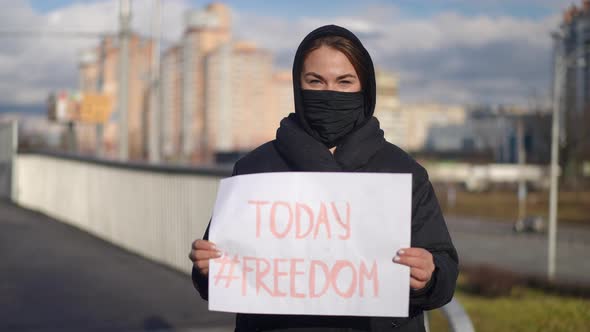 Front View Portrait of Young Caucasian Woman in Covid Face Mask with Freedom Today Placard in alt
