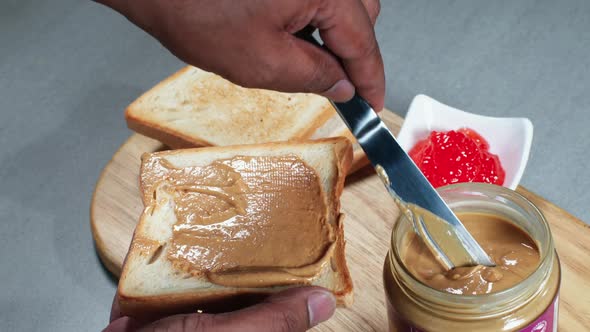 Spreading Peanut Butter On Bread  alt