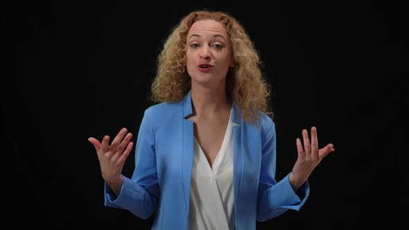 Persuasive Smiling Woman in Elegant Suit Talking Gesturing at Black Background alt