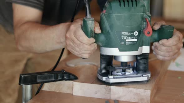 Craftsman forms a guitar in the shape of a wooden board