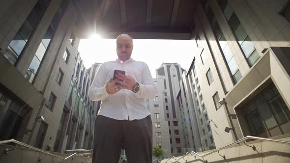 A Manager Makes a Phone Call Outside an Office Building alt