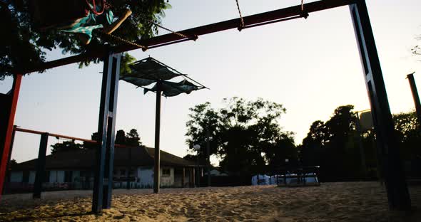 Children swinging together at a public playground alt