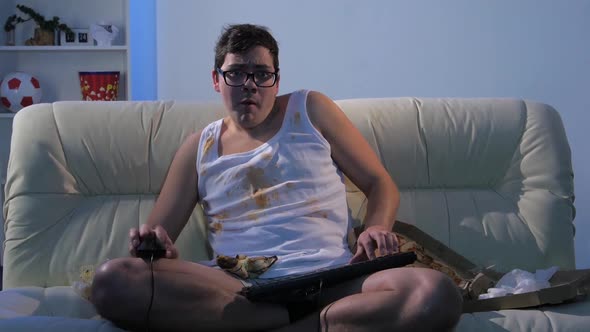 Gamer Sitting on Couch and Playing Games on the Network alt