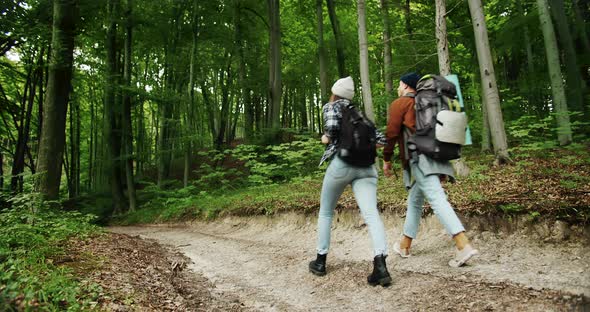 Couple of Backpacker Tourists Walking in Forest