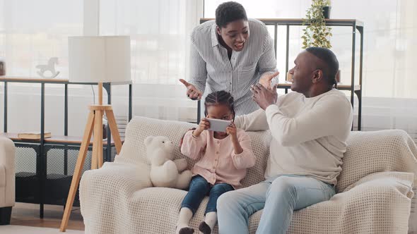 Afro American Man Father Grandfather with Little Girl Daughter Child Playing Mobile Online Video alt