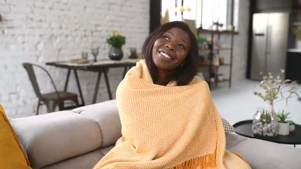 Young Multiracial Woman Covered in a Cozy Yellow Soft Blanket Staying at Home alt