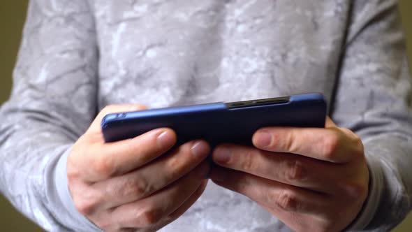 Closeup Shot of Hands of Man Active Playing in Smartphone Games