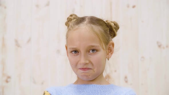Portrait Disgusted Girl Looking with Disgust on Light Background in Studio alt