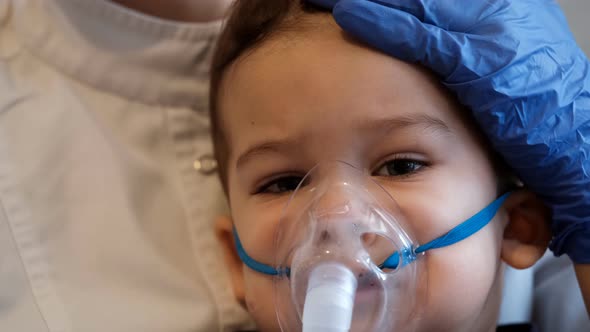 Inhalations for a Little Boy, The Doctor Carefully Performs the Procedure for the Child alt