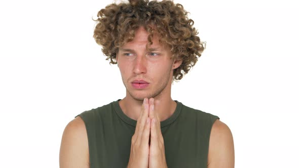 Portrait of Nervous Man with Curly Hair in Green Muscle Shirt Holding Hands Like Praying Thinking alt