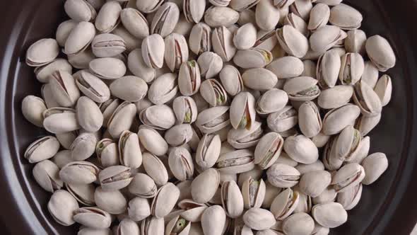 Salted vegan pistachio nuts in bowl close-up