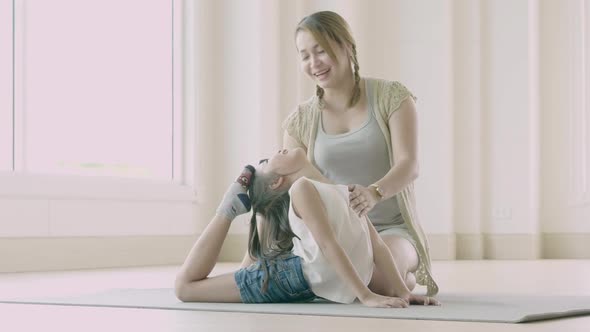 Asian mother and her daughter doing stretching exercise at home alt