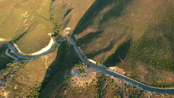 aerial top down view of a winding mountain road at sunset in South Africa alt