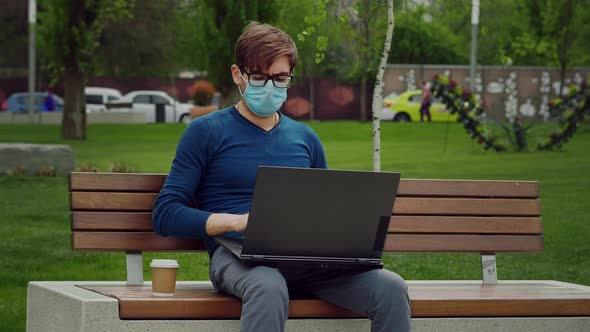 Young male opens laptop start typing writes email surfs the internet drinks coffee. alt