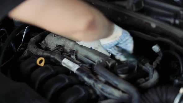 Male Auto Mechanic Changes Spark Plugs in a Car Engine