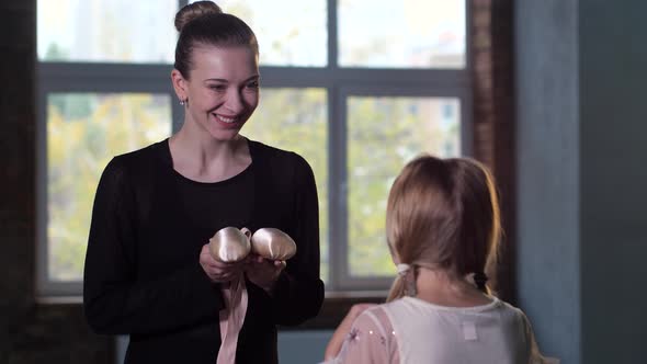 Choreographer Giving Pointe Shoes To Little Girl alt
