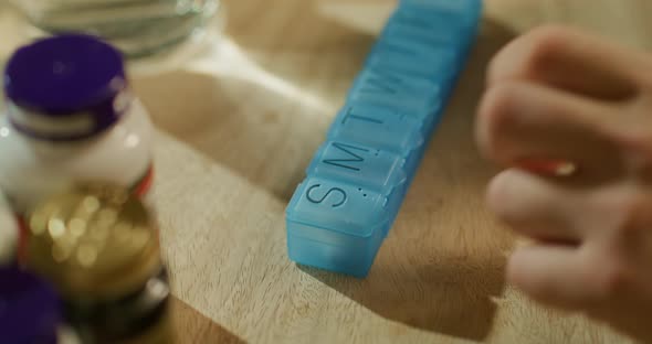 Man's Hands Taking Pills From Plastic Pill Organizer Box