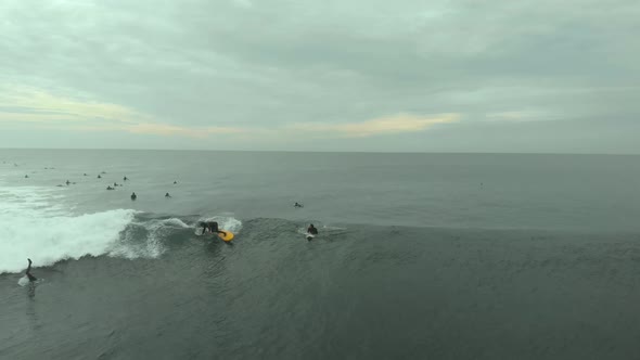 Aerial Shot of Pro Surfer riding big wave on a yellow board on a cloudy day in Pichilemu, Chile-4K alt