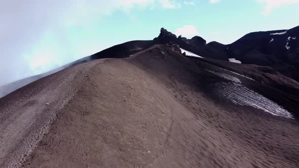 trail on a black volcano in the clouds