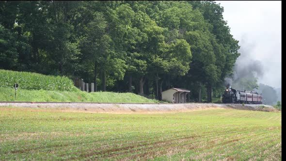 Steam Train Puffing Black Smoke Along Countryside alt