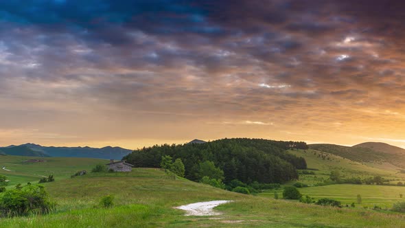 PAN: Sunset dramatic sky over Montelago highlands, Marche, Italy. Sunbeams among clouds above unique alt