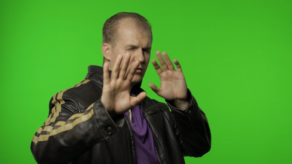 Confused Rocker Man Covering Eyes with Hand and Showing Stop Gesture, Expressing Disgust To Seen alt