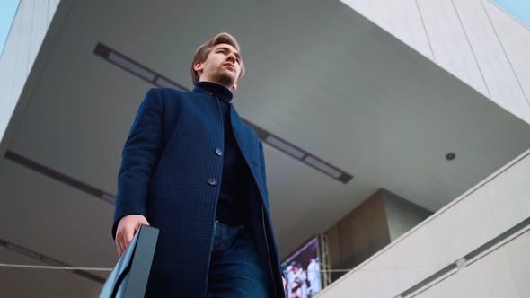 Serious Handsome Young Business Man Walking To Work in the Downtown. Bottom View alt