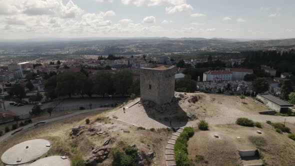 Slow drone pan around historic Guarda castle elevated on hill; Portugal