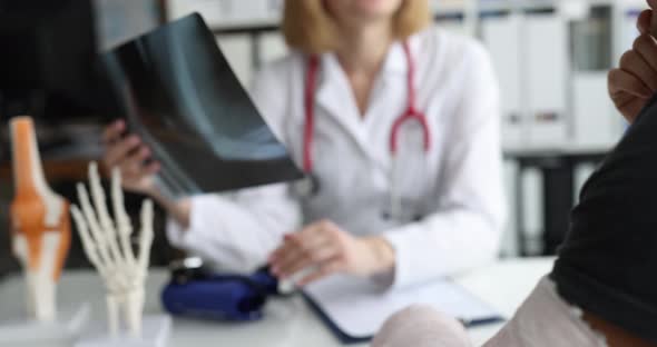 Doctor Traumatologist Examines Xray of Patient Hand with Fracture alt