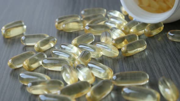 Spilled bottle of soft gel capsules slow pan 4K 2160p 30fps UltraHD footage - Cod liver oil medicine alt