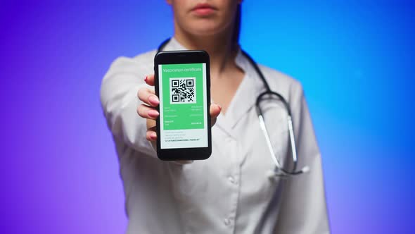 Woman Doctor in Medical Uniform Showing Vaccination Passport with Qr Code on Phone International alt