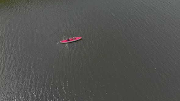 A Young Man and His Son Paddle in the Inflatable Kayak in a Sea or in a Lake alt