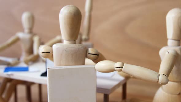 Wooden figurines having meeting in conference room alt