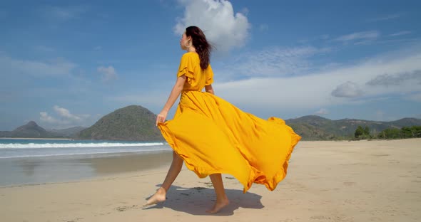 Beautiful Barefoot Young Lady Walking on the Sunny Beach Yellow Dress Fluttering in the Wind a Great alt