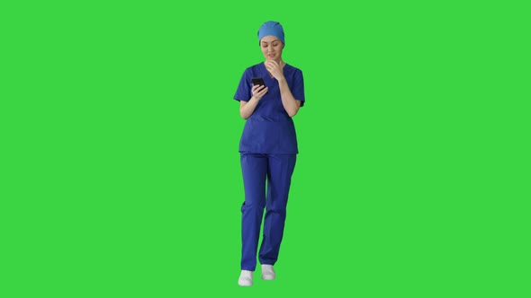 Thinking Female Doctor Using Her Smartphone on a Green Screen, Chroma Key. alt