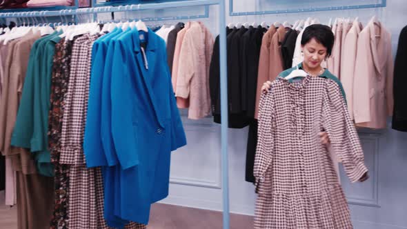 Fashion Designer Chooses Clothes Carefully Looking at Quality Shopping in a Clothing Store