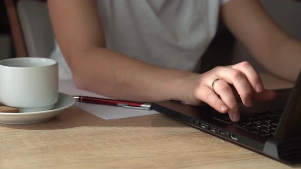 Close Up Hands Of Young Woman Chatting On Laptop At Home In Living Room