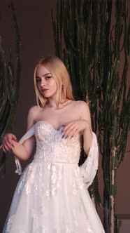 Young Blonde Woman in Elegant White Dress Posein Studio alt