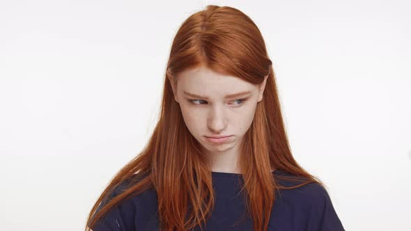 Cute Upset Caucasian Foxy Teenage Girl in Dark Blue Tshirt Looking at Camera Begging on White alt