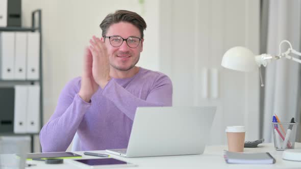 Middle Aged Man with Laptop Clapping alt