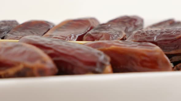 Dates palm dried exotic fruit on white reflective surface 4K 2160p UltraHD footage - Phoenix dactyli alt