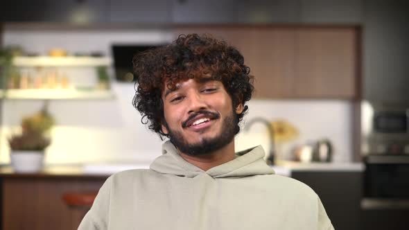 Smiling Curly Ethnic Man in Casual Hoodie Involved Virtual Meeting
