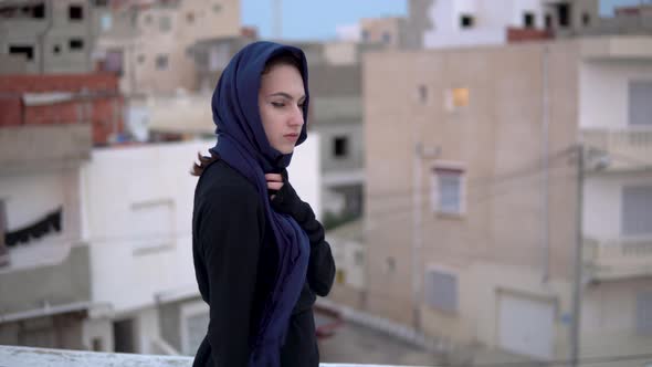 Young Woman in the Arab Headscarf. A Woman Is Walking on the Roof. On the Roof of the House alt
