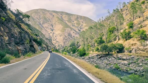 A View of a Road in the Mountains of California Through the Windshield of a Car alt