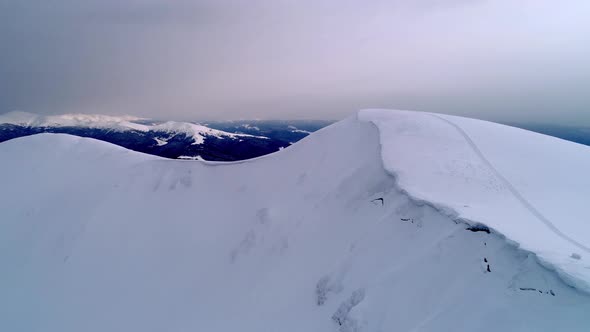 Flight over the snowy mountains illuminated by the evening sun alt