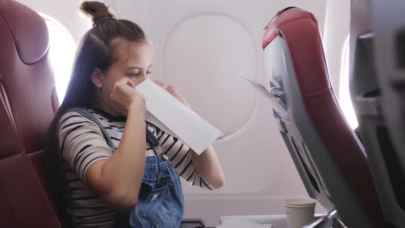 Teen Girl on the Plane Vomited in a Paper Bag