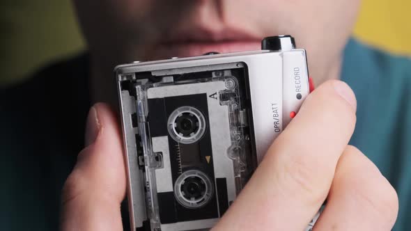 A Young Man Is Recording His Speech on a Portable Retro Cassette Recorder alt
