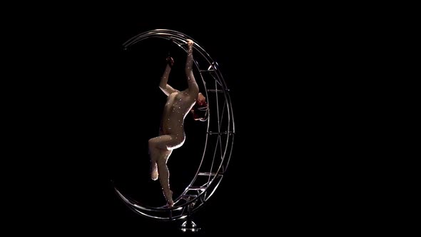 Acrobat a Rotating Design in the Form of a Moon. Black Background. Slow Motion alt
