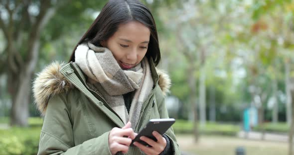 Woman use of mobile phone at park alt