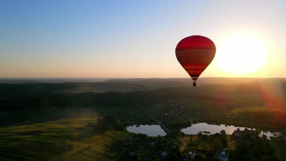 A Balloon Flies in the Middle of the Horizon at Sunset alt